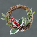 Rustic Christmas wreath with pinecones, red berries, and green foliage on a grey background.