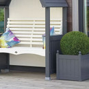 Close-up of the arbour bench seat and side planter, showing cream slatted back and charcoal posts beside a round topiary shrub.
