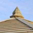 Close-up of the wooden roof finial and slatted roof detail of a garden gazebo.