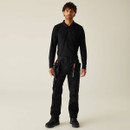 Full body: Male model wearing black utility work trousers with tool holsters, black long sleeve top and work boots, professional tradesman outfit.