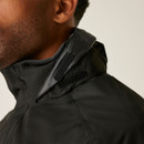 Close-up of the side of a person’s face and neck wearing a black jacket with a high collar. The fabric appears sleek and features Velcro strap details.