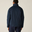 Rear view of a person in a navy jacket with a high collar, facing away. The neutral background enhances the jacket's dark hue and fitted style.