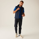 Full body shot of man wearing navy zip vest, blue t-shirt and jeans, casual utility outfit with modern workwear style