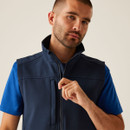 Male model adjusting navy zip vest collar, softshell gilet with high neck, modern workwear layering apparel