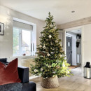 Decorated artificial Christmas tree with warm white lights and elegant baubles, styled in a modern living space for a classic Christmas display.