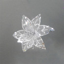 A silver glitter flower decoration against a grey background.