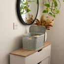 Light grey plastic storage basket with open lid placed on a wooden console table beneath a round mirror, styled with indoor plants and neutral home décor, showcasing practical home organisation use.