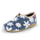 Angled front view of a women's slipper with plush navy fleece fabric featuring a white daisy and orange centre floral pattern, beige faux fur collar trim, tan rubber sole, and a pink woven brand label near the heel.