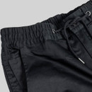 Close-up of elasticated waistband with drawstring and metal eyelets on black work trousers.