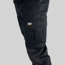 Close-up of black Caterpillar work trousers cargo pocket with flap closure and CAT logo branding.