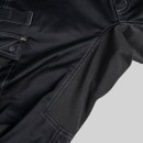 Detail of reinforced stretch panel on black CAT trousers with textured fabric and double stitching