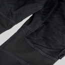 Angled view of multi-compartment cargo pocket on black CAT trousers with stitched sections and secure flap