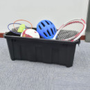 A black storage bin on a gray carpet holds a blue helmet, badminton rackets, a soccer ball, and a tennis racket, conveying an active, sporty tone.