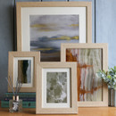 A collection of four oak effect photo frames of varying sizes.