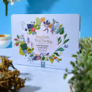 Colourful English Tea Shop tin with floral and leaf patterns on a light blue background. The design includes small, whimsical figures.