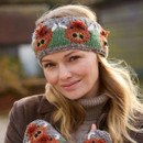 A woman wearing a knitted headband featuring red bird designs smiles softly. She matches it with mittens featuring the same pattern, set against a blurred outdoor background. A woman wearing a knitted headband featuring red bird designs smiles softly. She matches it with mittens featuring the same pattern, set against a blurred outdoor background.