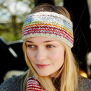 A woman in a colourful knitted headband and jumper gazes serenely to the side with a soft smile. The background is a blurred outdoor setting.