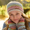 Smiling woman in a colourful knit headband and gloves, outdoors in a sunlit autumn setting. Warm, cheerful tones and cosiness are conveyed.