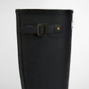 Close-up of the adjustable buckle strap on a black Barbour wellington boot shaft.
