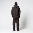 Back view of a man wearing a dark brown hooded outdoor jacket and matching trousers.