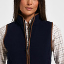 Close-up front view of a navy fleece gilet showing the high collar, brown edging and zip fastening.