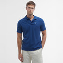 Man wearing a blue polo shirt and beige pants stands against a plain white background. He appears relaxed and confident, conveying a casual style.