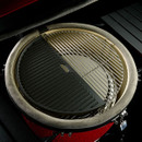 Close-up of a round grill surface, featuring a dual cooking area with a smooth black section and a wire rack, set in a red grill.