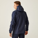 A person wearing a navy rain jacket with a hood, viewed from the back, stands against a plain light background, conveying a casual, outdoorsy vibe.