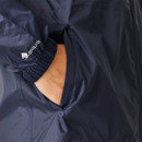 A close-up of a hand in the pocket of a navy blue jacket. The jacket has elastic cuffs and a subtle logo on the sleeve, conveying a casual tone.