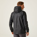 Man in a black hooded jacket stands with his back to the camera, turning slightly to the right. The background is plain and neutral, creating a minimalist feel.