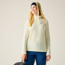 Model wearing a cream Regatta half-zip fleece with high collar, styled with blue outdoor shorts and a navy headband.
