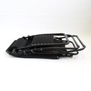 A folded black outdoor recliner chair with a sleek metal frame resting on a light background.