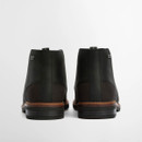 Rear view of black leather chukka boots with pull tabs and contrast brown sole, displayed side by side on a white background.