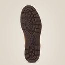 Brown boot sole with deep treads and hexagonal patterns on a light beige background, conveying durability and outdoor utility.