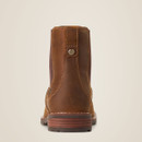 Brown leather boot viewed from the back, showcasing detailed stitching and a button accent on a tan background, conveying a rugged, stylish tone.