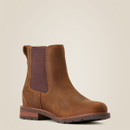 A brown leather Chelsea boot with a dark elastic side panel and pull tab. The boot features a sturdy, textured sole, set against a light beige background.