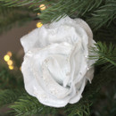A view of a white velvet rose clip on decoration on a Christmas tree