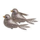 Two sparkling, glitter-covered birds with orange beaks and intricately designed tails, side by side against a white background.