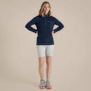 Full-length studio shot of women’s navy quarter-zip fleece top paired with light shorts and walking shoes.