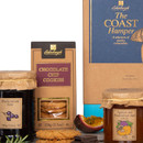 Close-up of Coast Hamper products showing Chocolate Chip Cookies, Blackcurrant Jam, and Apricot & Peach Preserve with pieces of chocolate and fruit garnish.