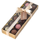 Luxury Van Roy chocolate assortment presented in a gold gift box with a satin cream ribbon and tag, containing an elegant selection of milk, dark, white and pink truffles.