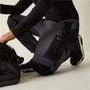 Close-up of worker kneeling in reinforced work pants with Cordura knee panels, adjustable tool pouch, and heavy-duty stitching for durability and flexibility on job sites.