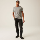 Full-body view of male model wearing black technical work trousers and grey t-shirt, showcasing slim-fit design, multi-pocket functionality, and rugged workwear styling.