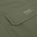 Close-up of Hoggs Professional branding embroidered on the pocket flap of a dark olive green outdoor jacket.