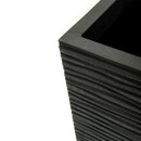 Close-up of a black, square planter with a textured, wavy pattern. The clean lines and modern design convey a sleek and minimalist style.