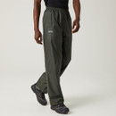 A person wearing dark green waterproof trousers and black shoes walks on a neutral background. The trousers have an elastic waistband and a relaxed fit. A person wearing dark green waterproof trousers and black shoes walks on a neutral background. The trousers have an elastic waistband and a relaxed fit.