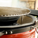 Close-up of a red grill with a smoke-releasing plate, showcasing a cooking surface and steam rising from the heat inside.
