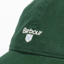 Green baseball cap with "Barbour" embroidered in white on the side. Below the text is a small shield logo with a blue cross on a white background.