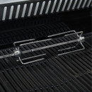Rotisserie rod with forks resting on barbecue grill grates.