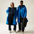 A full length view of a woman and a man wearing a bright blue waterproof robe.